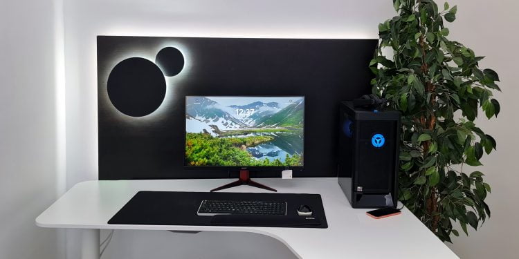 Minimalistinen tietokonekokoonpano, jossa on kaareva valkoinen työpöytä. Näytöllä näkyy upea vuoristomaisema, joka saa lisävalaistusta LED-taustavalosta. Sen vieressä on musta PC-torni, jossa hehkuu sinisiä LED-yksityiskohtia. Kokonaisuuden täydentää seinällä oleva abstrakti taide teos pyöreine muotoineen sekä huonekasvi. tyylikäs ja moderni asettelu on Tämä esimerkki esimerkki siitä, miten LedStore.fi:n laadukkaat LED-valaistusratkaisut voivat tuoda uutta eloa kotitoimistoon tai työtilaan!