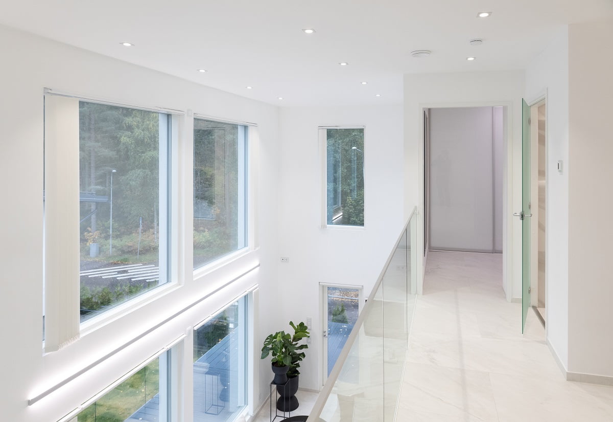 Valoisa ja moderni sisäkäytävä, jossa on suuret ikkunat molemmin puolin, antaa luonnonvalon tulvia sisään. Tilassa on valkoiset seinät ja upotettu LED-valaistus, joka lasten tunnelmaa. Lasinen kaide tuo tyylikkyyttä. Vihreä ruukkukasvi lisää raikkaan väripilkun kokonaisuuteen. Tervetuloa tutustumaan LedStore.fi:n laadukkaaseen LED-valaistuksen valikoimaan ja luomaan unelmiesi valoisa tila!